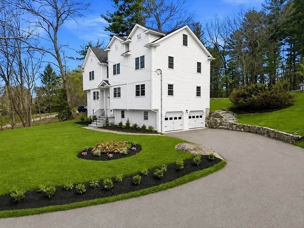 A newly built colonial with a curved driveway.